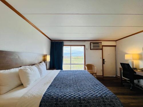 斩魔山Mariner Inn And Suites的一间带床、书桌和窗户的酒店房间