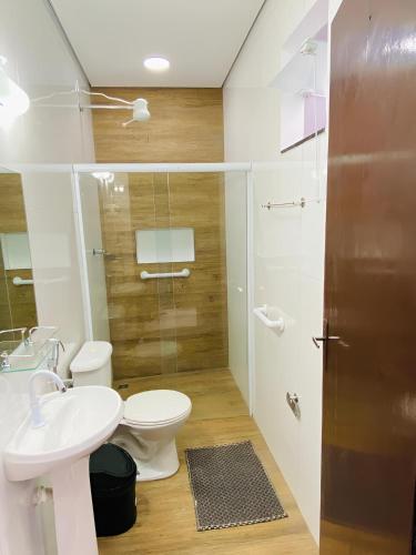 a bathroom with a toilet and a sink and a shower at Mar Suites Tenório in Ubatuba