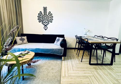 uma sala de estar com um sofá e uma mesa em Apartamenty Trimont nad Jeziorem Czorsztyńskim em Kluszkowce
