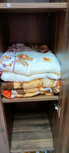 a shelf with three folded blankets on it at Homestay RAHMAJID in Segamat
