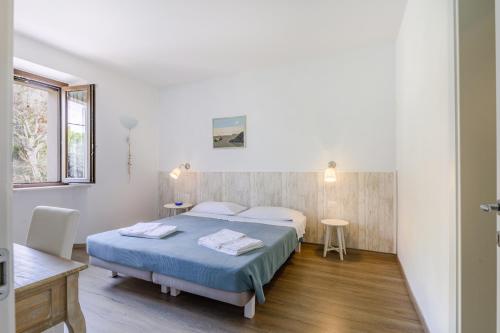 a bedroom with two beds and a table and a window at B&B Isa in Loreto