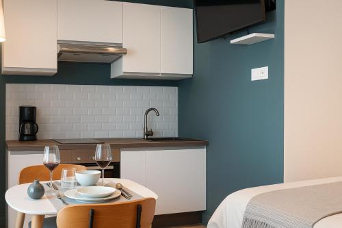 una cucina con tavolo e 2 bicchieri di vino di Le studio Belledonne de Paradis a Chambéry