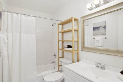 a bathroom with a toilet and a sink and a mirror at Private Beach and Pool in Gulf Shores