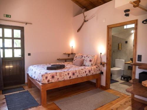 a bedroom with a bed and a bathroom at Casa Rosa - Casas Florescer in Fajazinha