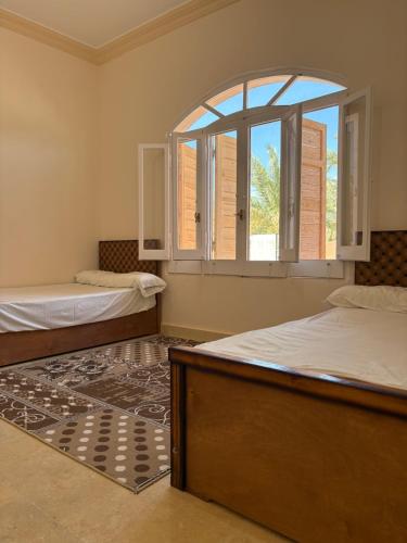 锡瓦Bakrine chalet的客房设有两张床和大窗户。