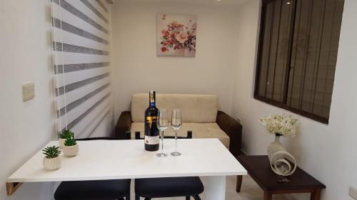 een witte tafel met twee flessen en wijnglazen erop bij Suite Numa in Cuenca