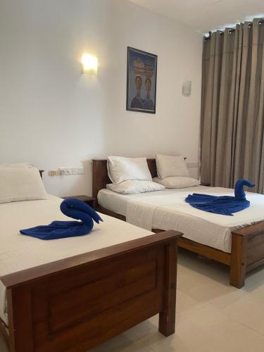 duas camas num quarto com toalhas azuis em Walaw watta resort em Mirissa
