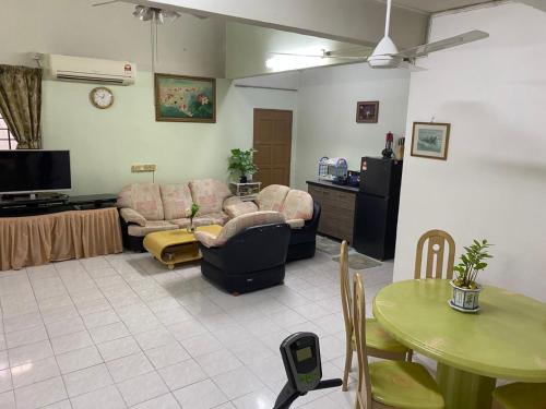 una sala de estar con un sofá y una mesa en Comfortable Retreat in Megah Ria, en Masai