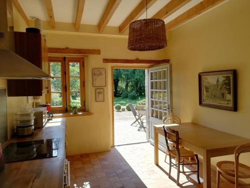 une cuisine avec une table et une salle à manger dans l'établissement charmante longère sur domaine de Kerguéréon, à Ploubezre