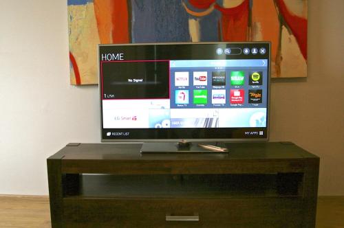 a flat screen tv sitting on top of a wooden table at More Guesthouse in More