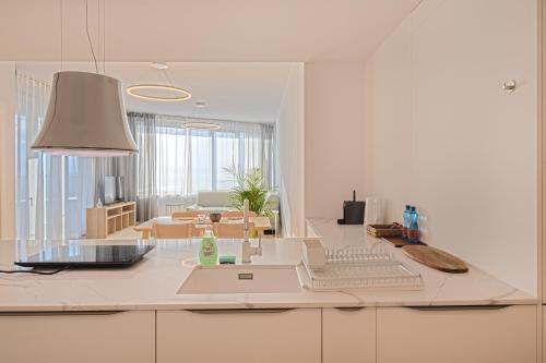 a white kitchen with a laptop computer on a counter at Skau Sky Park Mint by Zaha Hadid 22 Floor 1 Tower Free Parking in Staré Mesto