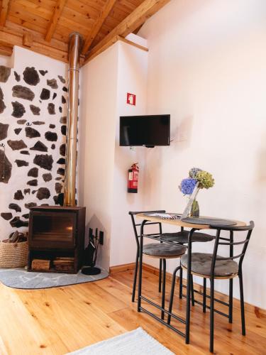 a room with a table and chairs and a fireplace at Casa Rosa - Casas Florescer in Fajazinha