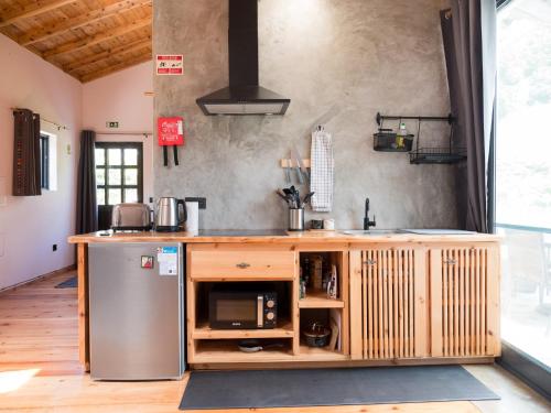 een keuken met een aanrecht met een wastafel en een koelkast bij Casa Flor - Flower home in Fajazinha