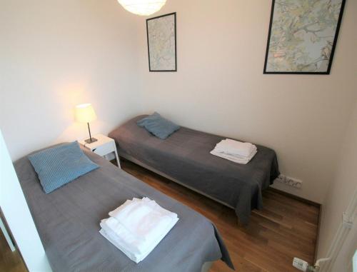 a bedroom with two beds and a lamp in it at Central Studio for 2 in Lahti