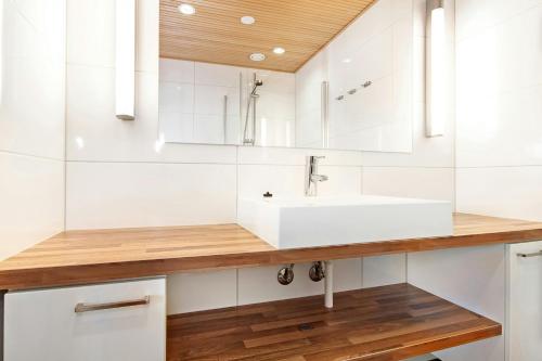 een badkamer met een wastafel en een spiegel bij Spacious Apartment for 6 with Sauna in Harviala