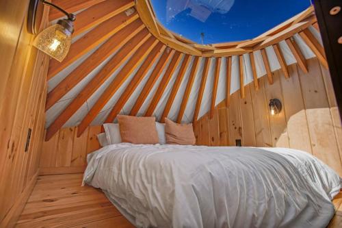 a bedroom with a bed in a wooden ceiling at Sunrise Sanctuary -Modern Yurt in Brookville