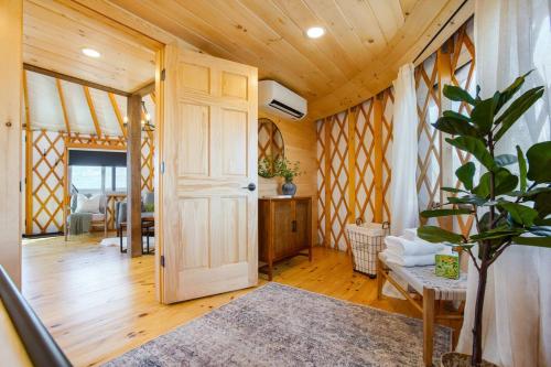 a room with a wooden door and a room with a table at Starlit Haven - Modern Yurt in Brookville
