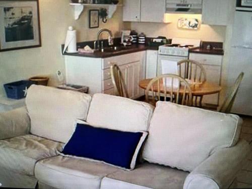 a living room with a white couch with a blue pillow at Lazy Shell Condo 325 in Cedar Key