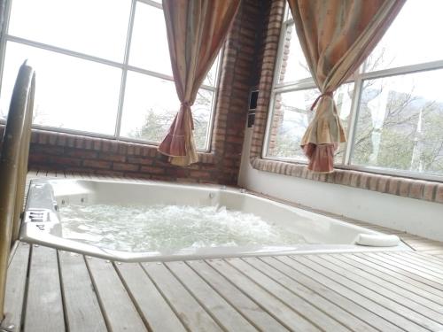 a bath tub in a room with windows at Complejo Turístico Hugo Ávila in La Rioja