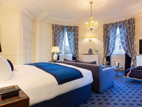a large bedroom with a large bed and a couch at Le Royal Hotel Lyon - MGallery Collection in Lyon