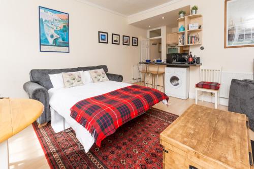 a bedroom with a bed with a plaid blanket at Luxury New Town 1 Bed Apartment in Edinburgh