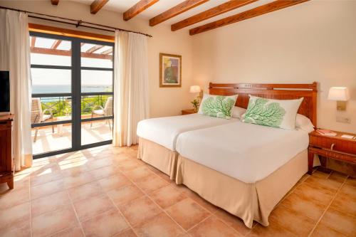 a bedroom with a bed and a view of the ocean at Princesa Yaiza Suite Hotel Resort in Playa Blanca