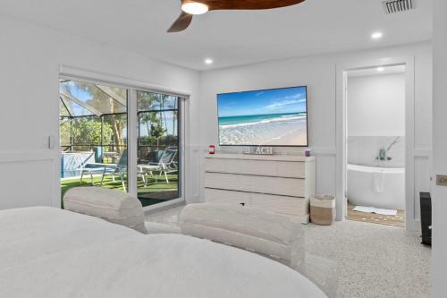 1 dormitorio con cama, bañera y TV en Islandy, en Sanibel