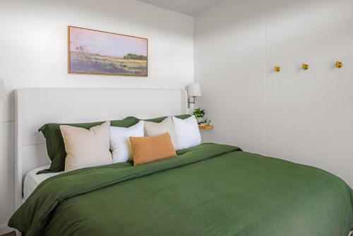 een slaapkamer met een groen bed en meerdere kussens bij Twilight Haven - Hot Tub in Shippenville