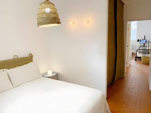 Un dormitorio con una cama blanca y un pasillo. en U Canetta 1, en Pietra Ligure