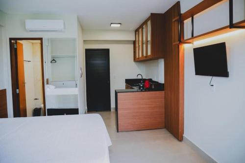 a room with a bedroom with a bed and a tv at Loft completo e climatizado a 2 minutos do centro in Cuiabá