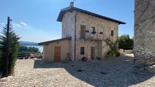 an old stone building with a balcony on top at Beut Home Apartments in Gavirate