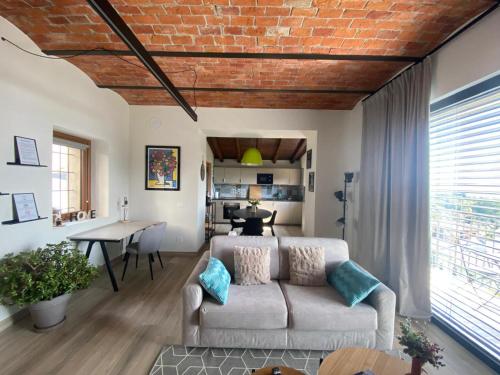 a living room with a couch and a brick wall at Beut Home Apartments in Gavirate