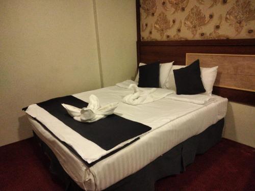 a large bed with white towels on top of it at فندق لؤلؤة الجوار مكه in Makkah