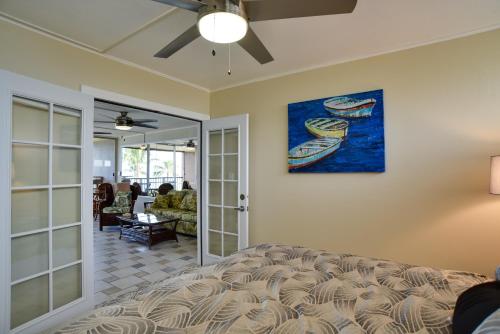 a living room with a couch and a painting on the wall at Oceanfront Lahaina Condo with Balcony and Pool Access! in Kahana
