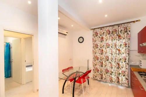 a dining room with a glass table and red chairs at Villa tranquilla immersa nel verde a 2 Km dal mare in Chiavari