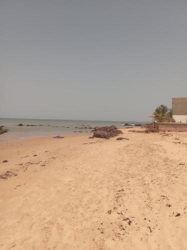 a sandy beach with footprints in the sand at Chez André Léon in Ngaparou