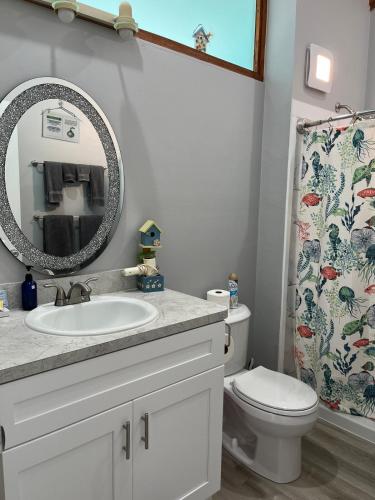 a bathroom with a sink and a toilet and a mirror at Sunset Vista Condo 328 in Cedar Key
