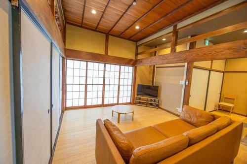 a large living room with a couch and a television at 海が見える1棟貸し!バレルサウナ付きの家族で泊まれる貸し別荘!絶景とプライベート空間を満喫! in Higashiizu