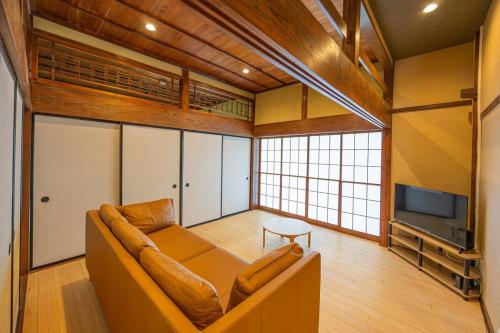 a living room with a couch and a tv at 海が見える1棟貸し!バレルサウナ付きの家族で泊まれる貸し別荘!絶景とプライベート空間を満喫! in Higashiizu