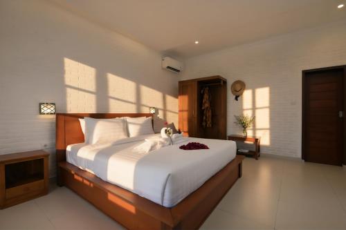 a bedroom with a large bed with white sheets at Kubu Daje Villa Canggu 2BR With Private Pool in Dalung