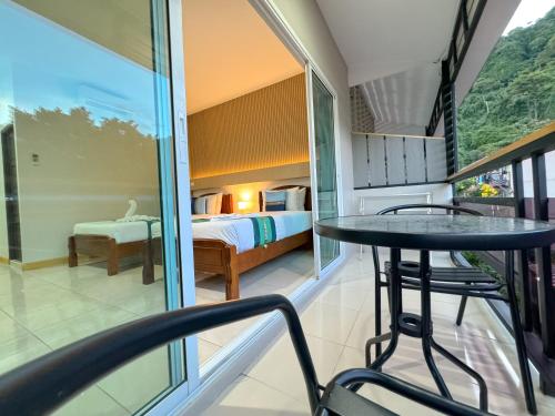 a room with a bed and a table and chairs at Chongkhao Resort- Phi Phi Island in Phi Phi Don
