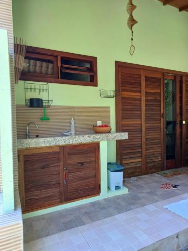 a kitchen with wooden cabinets and a counter top at Cafofo de Dri in Ilha de Boipeba