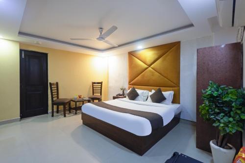 um quarto de hotel com uma cama e uma mesa em Hotel Krone By RMAAP Hotels em Nova Deli