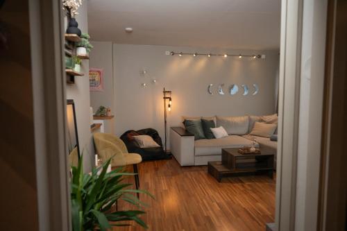 Una sala de estar con un sofá blanco y una mesa. en Cozy Penthouse Private Balcony City Centre, en Stavanger