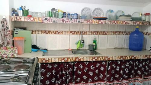 a kitchen with a sink and a counter with dishes at Guest house in Canoa