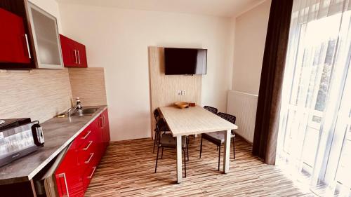 a kitchen with a table with chairs and a tv at Penzion Ranch in Hořovice