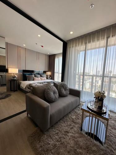 ein Wohnzimmer mit einer Couch und einem Bett in der Unterkunft The Panora Pattaya Top Luxury Seaview Condo in Pattaya South