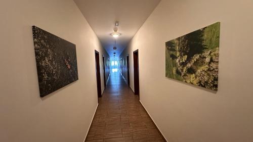 un corridoio con tre dipinti alle pareti di Penzion Ranch a Hořovice