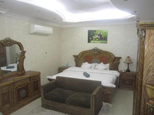 a bedroom with a large bed and a mirror at العين الهيلي مصباح بيت 5 in Al Ain