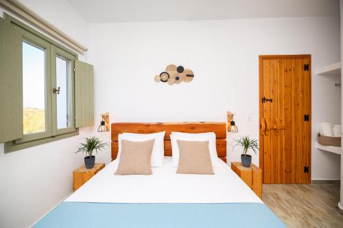 a bedroom with a large bed with two potted plants at Eleonas I in Maragkas